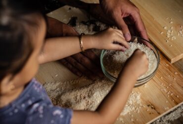person holding white powder on brown wooden table