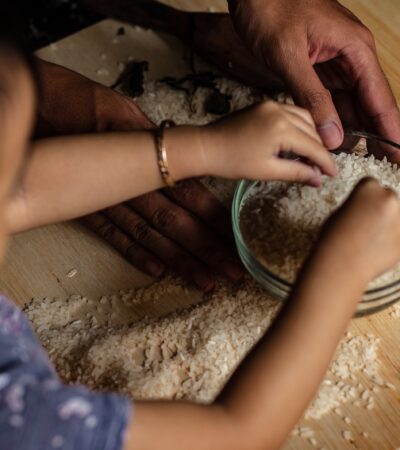 person holding white powder on brown wooden table