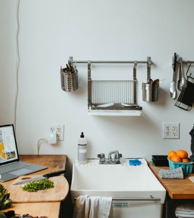 a man standing in a kitchen next to a laptop computer