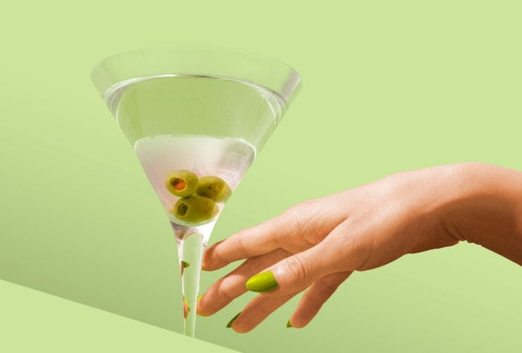 person holding clear drinking glass with white liquid