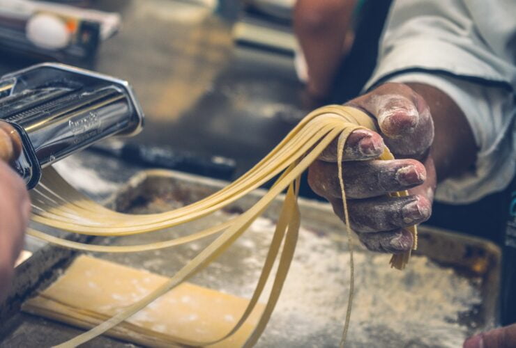 person sheeting dough