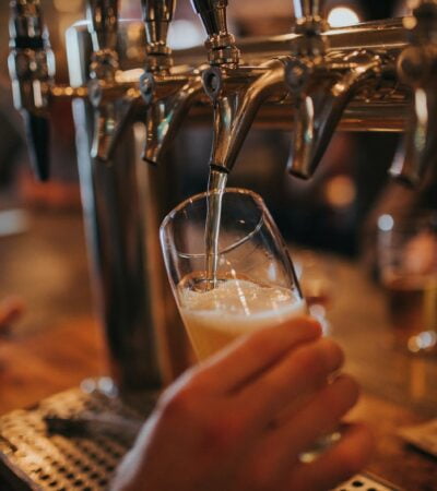 person filling beer on glass