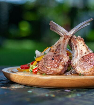 a wooden plate topped with meat and vegetables