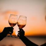 silhouette photography of two person holding long-stem wine glasses